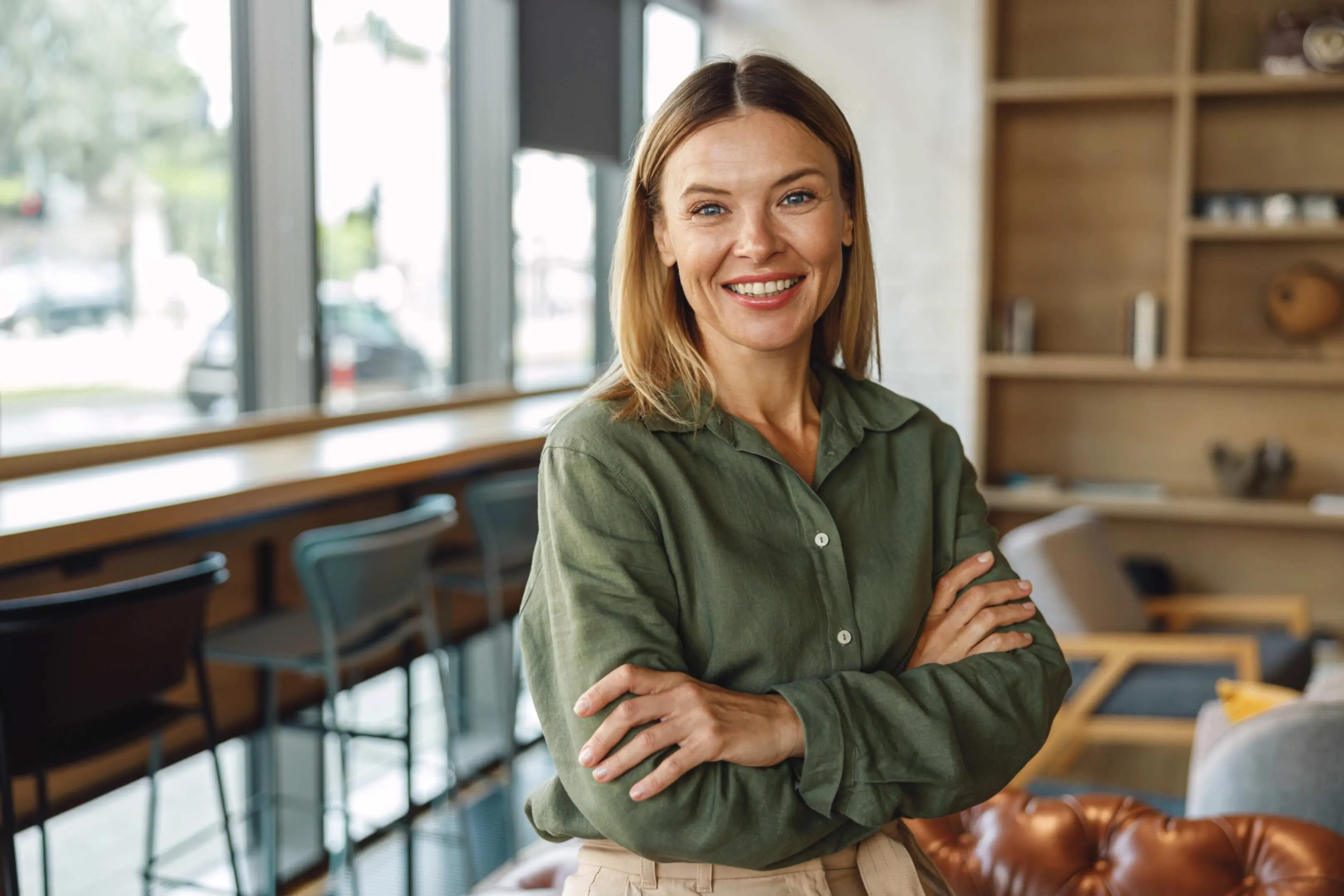 Smiling woman standing in cozy cafe.