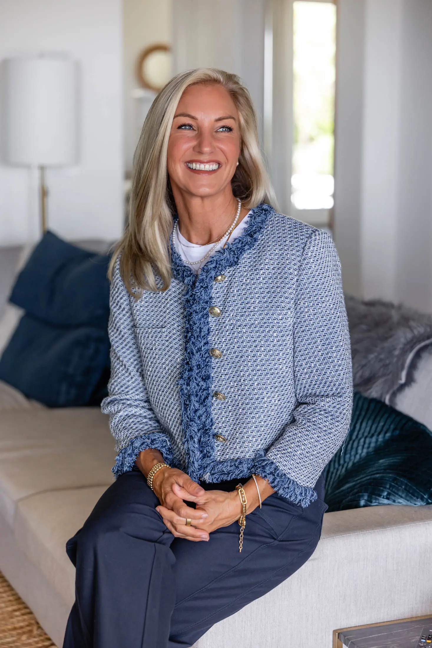 Woman smiling while sitting on a sofa.