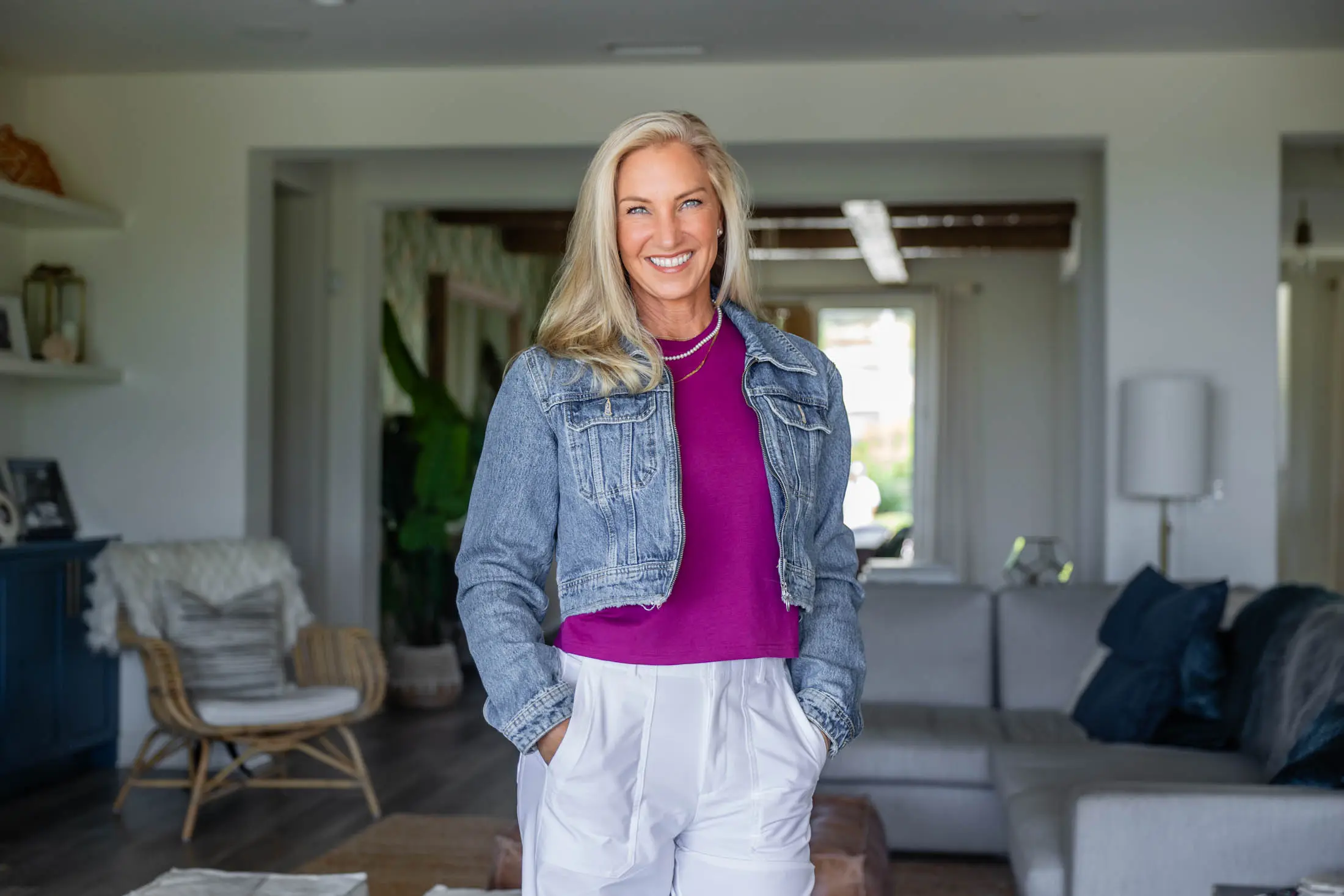 Smiling woman in living room, casual attire.