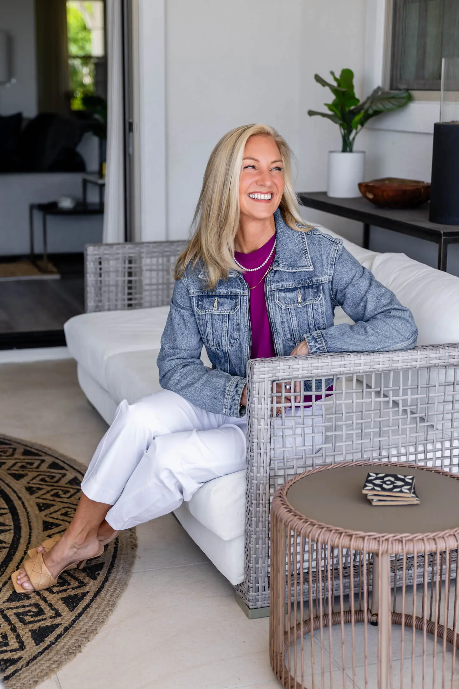 Smiling woman sitting on a white couch.