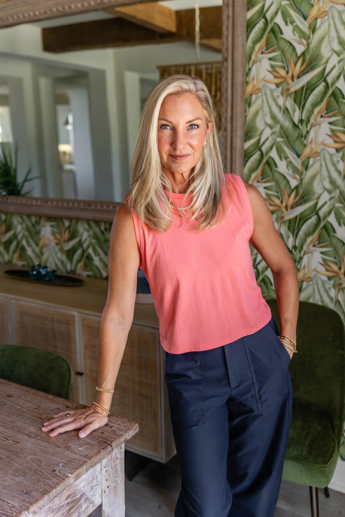 Woman in pink top, standing indoors.