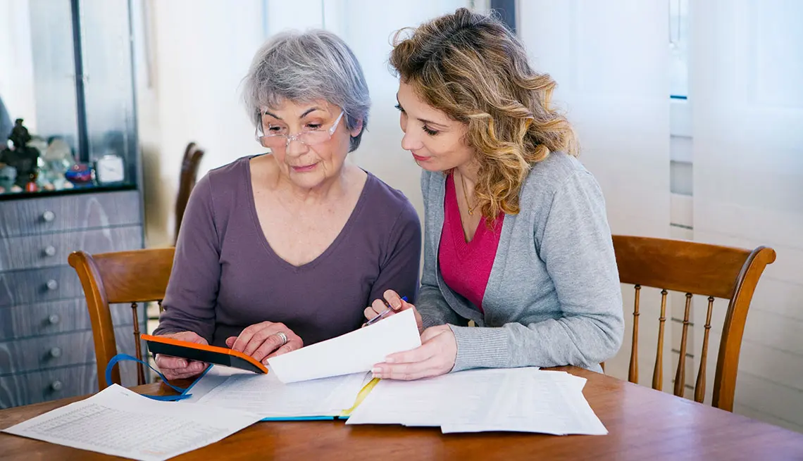 Two women reviewing documents at table.