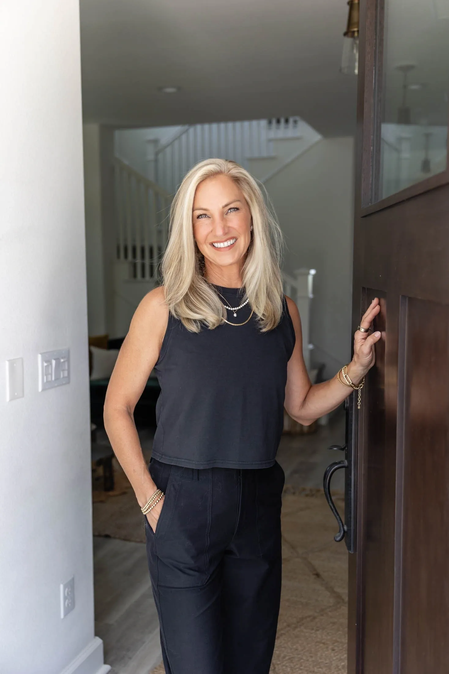 Smiling person standing in doorway, indoors.