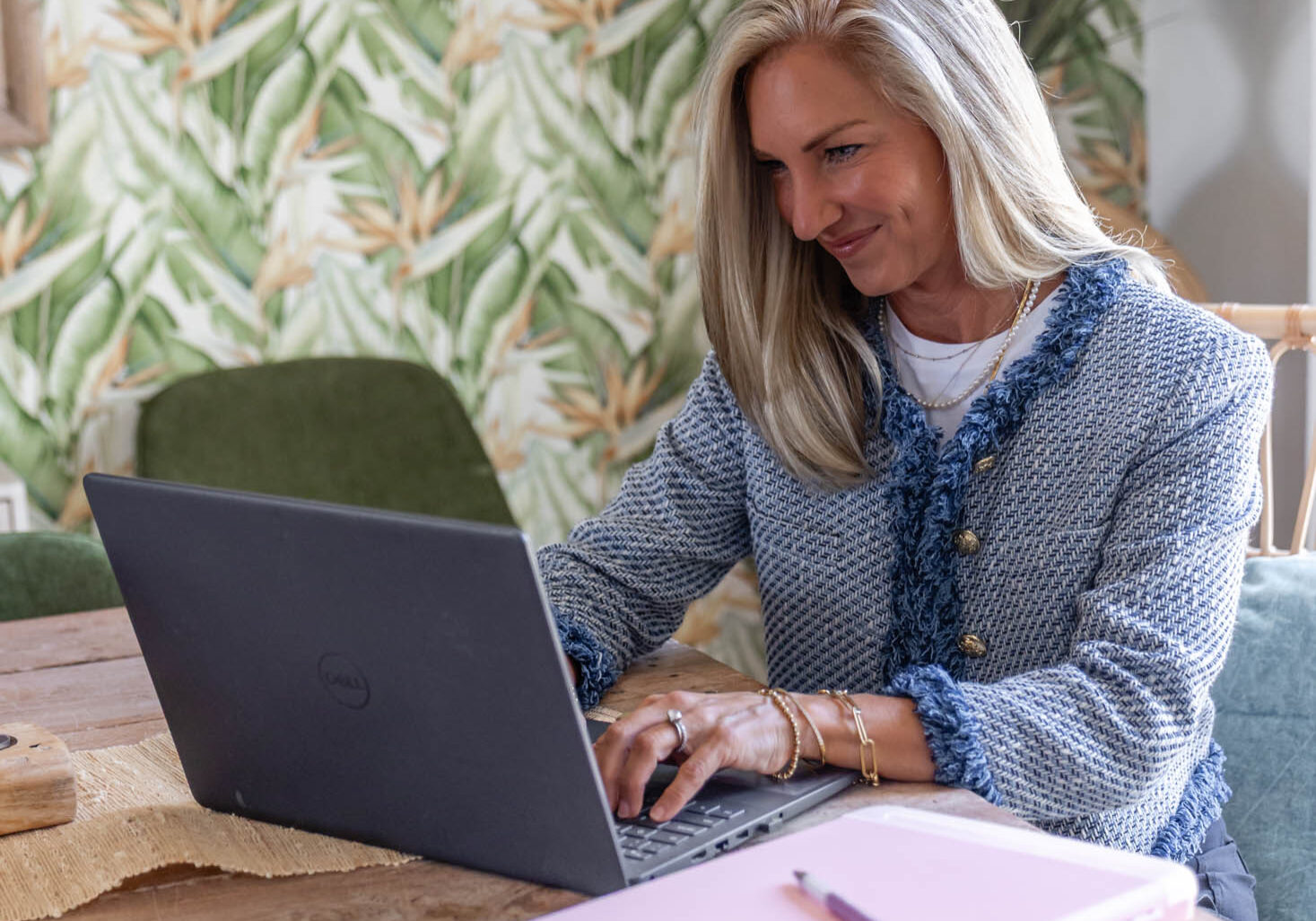Woman working on laptop at wooden table.